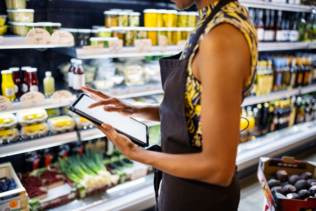 Woman checking iPad in grocery store